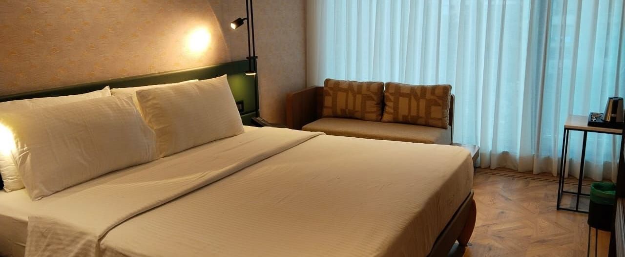 A king size bed in the Deluxe Room at Regency Hotel, Mumbai.