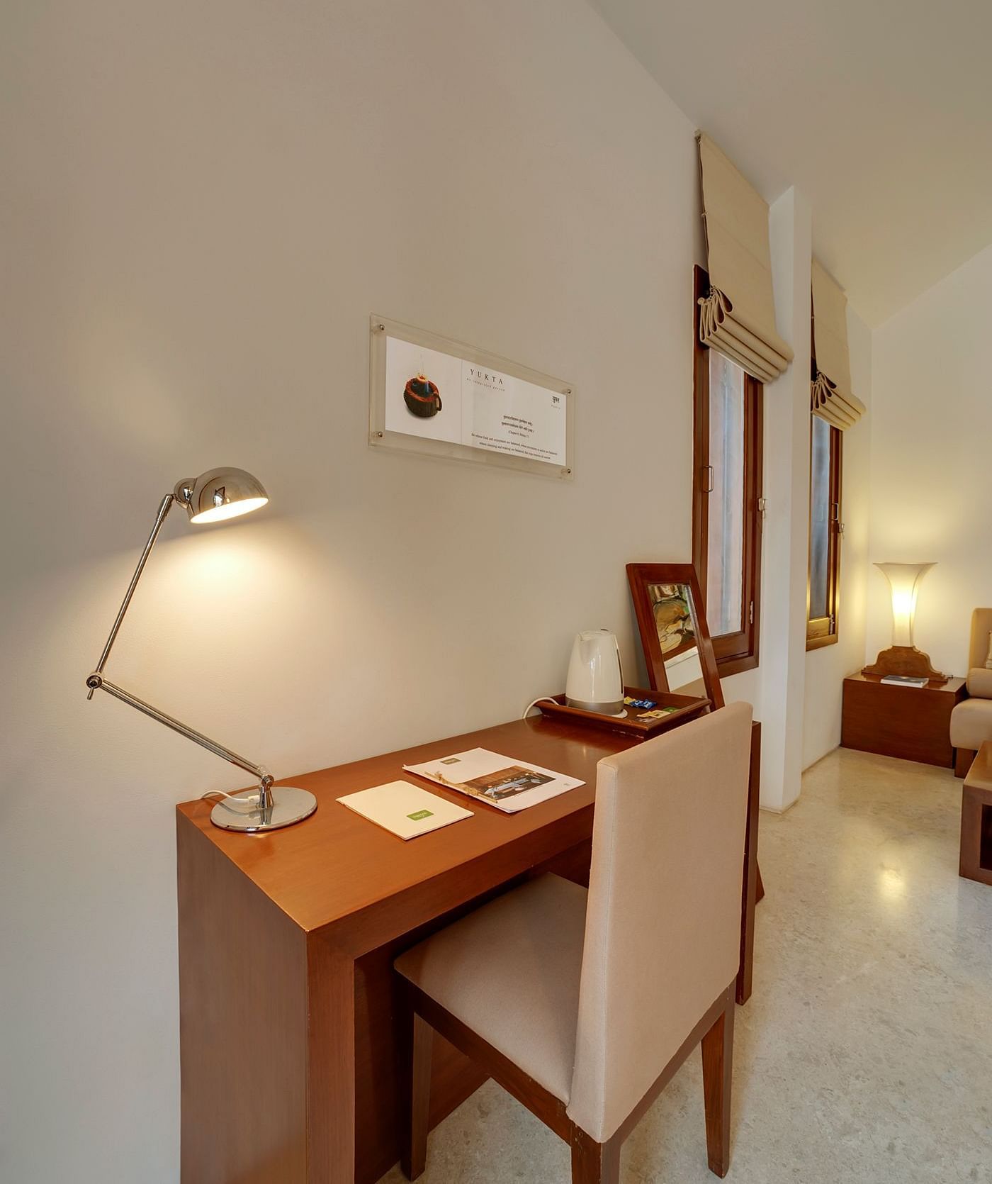 A side table with a lamp, stationery, and a decorative piece - Shreyas Retreat