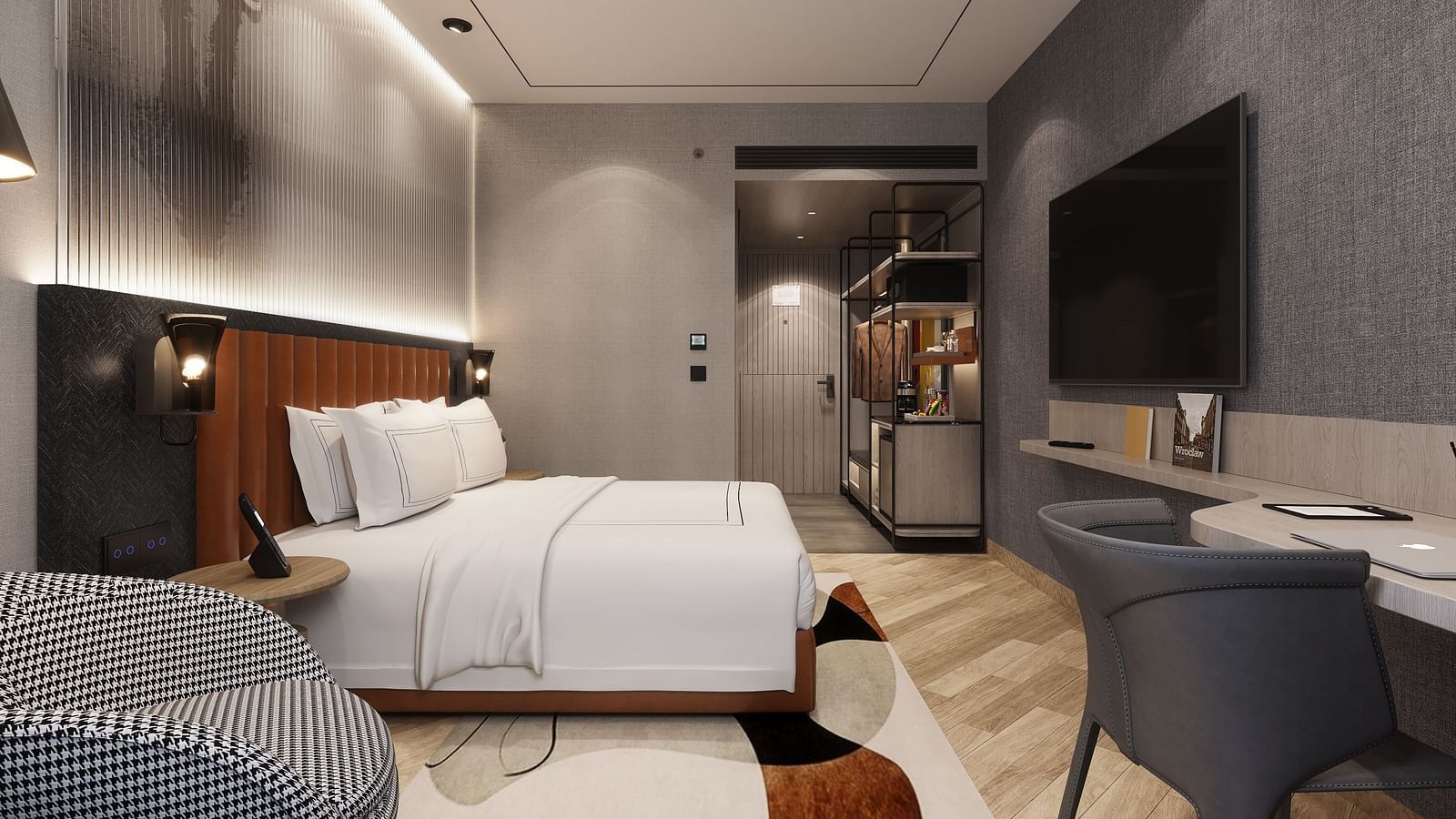 Interior view of a hotel room with a made bed, desk, chair, TV, and a partial view of a closet area.