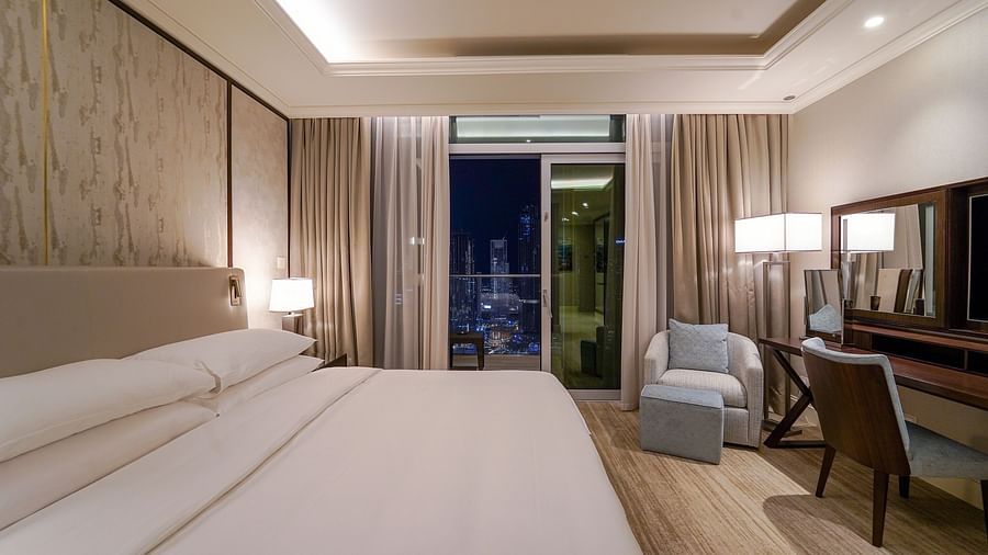 Address Fountain Views Residence Tower - the king size bed facing the TV with the curtains of the window open 1