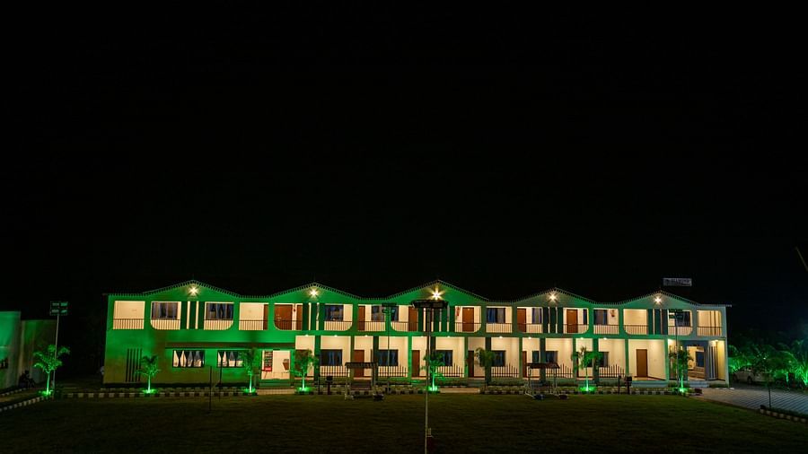 A peaceful view of the resort’s lawn and the facade at night, lit by soft green lights - VITS Select Diamond Resort, Sasan Gir
