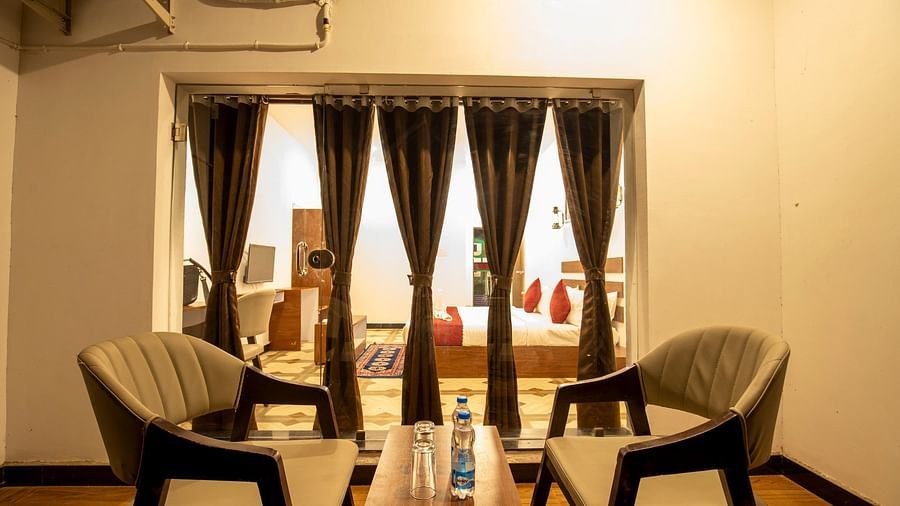 seating area in the balcony of the suite with neatly pleated curtains - VITS Select Diamond Resort, Sasan Gir