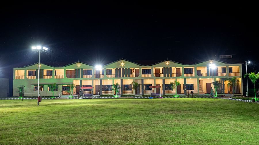 A wide-angle night view of the resort’s lawn with the buildings illuminated, creating a peaceful and welcoming ambience - VITS Select Diamond Resort, Sasan Gir