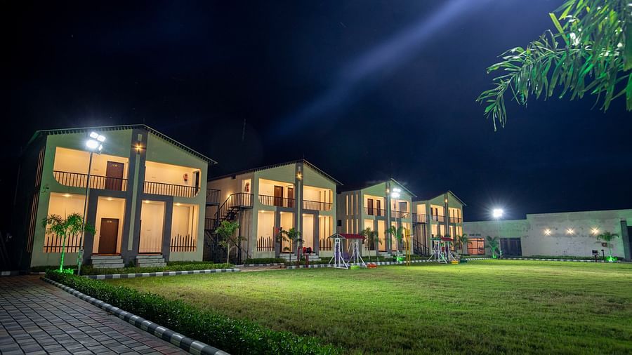  A wide shot of the resort's outdoor grounds, displaying a vast open lawn taken during the night - VITS Select Diamond Resort, Sasan Gir