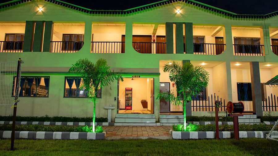  A night time view of the resort’s facade illuminated with green lighting, creating a serene and welcoming atmosphere - VITS Select Diamond Resort, Sasan Gir