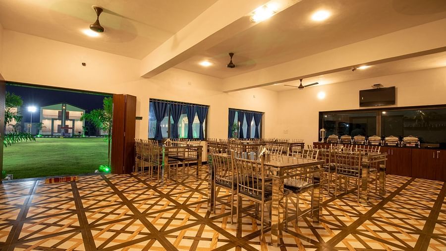Corner view image of the restaurant with tables, chairs, and decorative floor tiles - VITS Select Diamond Resort, Sasan Gir
