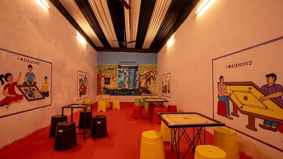 A fun indoor space with creative wall art, brightly coloured seating, and a lively red floor, designed for children's play - VITS Select Diamond Resort, Sasan Gir