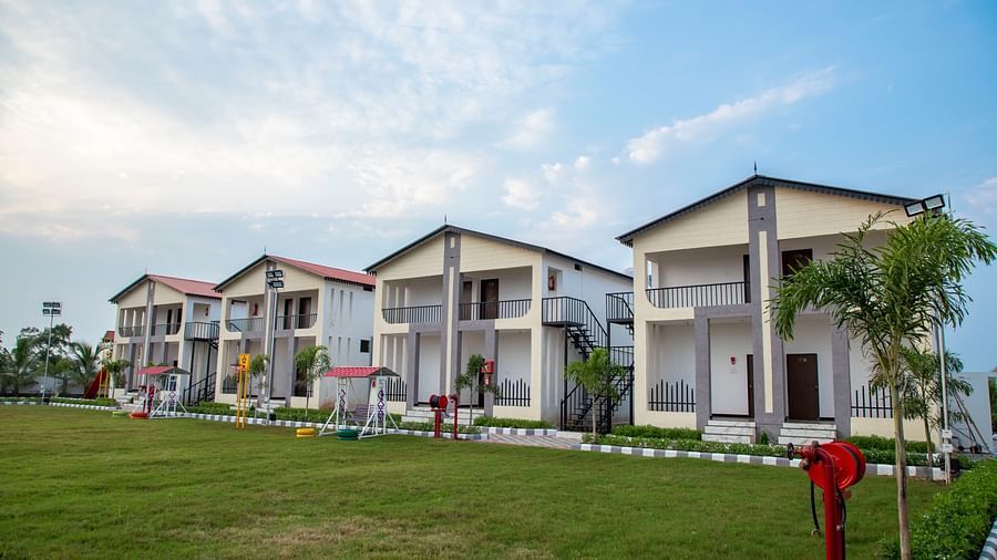 A wide-angle view of the resort’s expansive grounds, featuring the building and a well-kept lawn in the background - VITS Select Diamond Resort, Sasan Gir