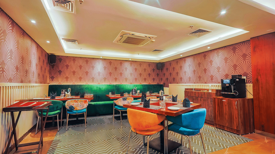 A modern restaurant dining area with colourful chairs and stylish decor - Hyphen Business Hotel, Noida