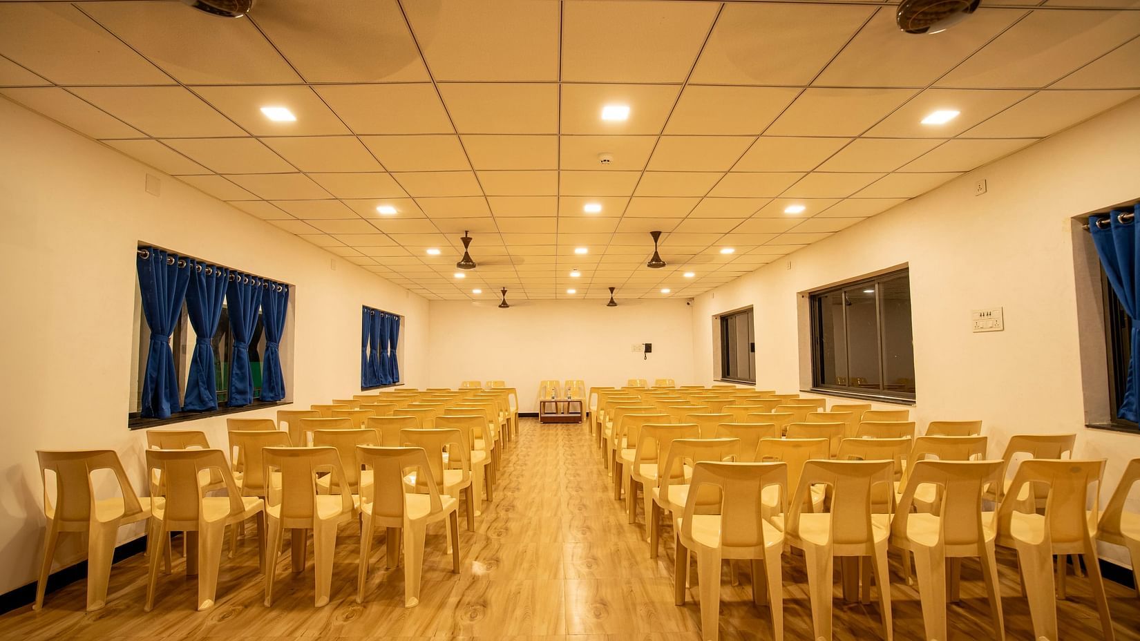 A well-lit event hall with neatly arranged rows of chairs, ready for an upcoming event or conference - VITS Select Diamond Resort, Sasan Gir