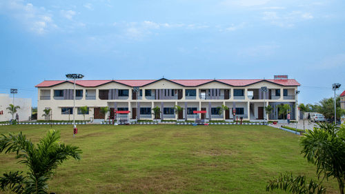 A wide shot of the resort building surrounded by a lush green lawn, showcasing the spacious and serene environment - VITS Select Diamond Resort, Sasan Gir