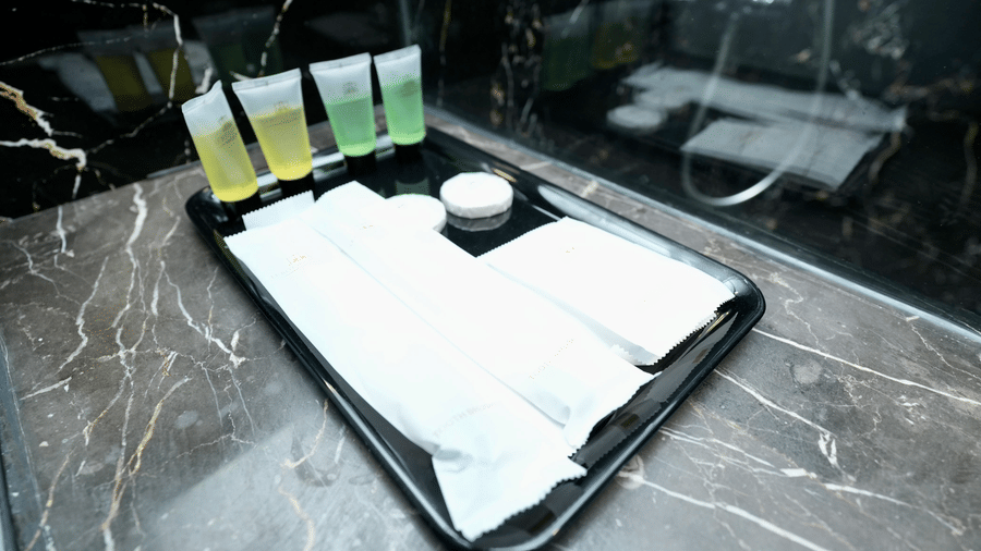 A bathroom amenity setup in the Deluxe Quadruple Room at Le Royale Palace with neatly arranged toiletries on a marble counter