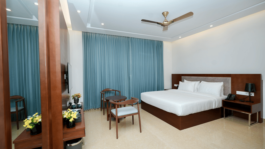 A spacious Executive King Room at Le Royale Palace with modern lighting, comfortable bed, and a cozy sitting corner
