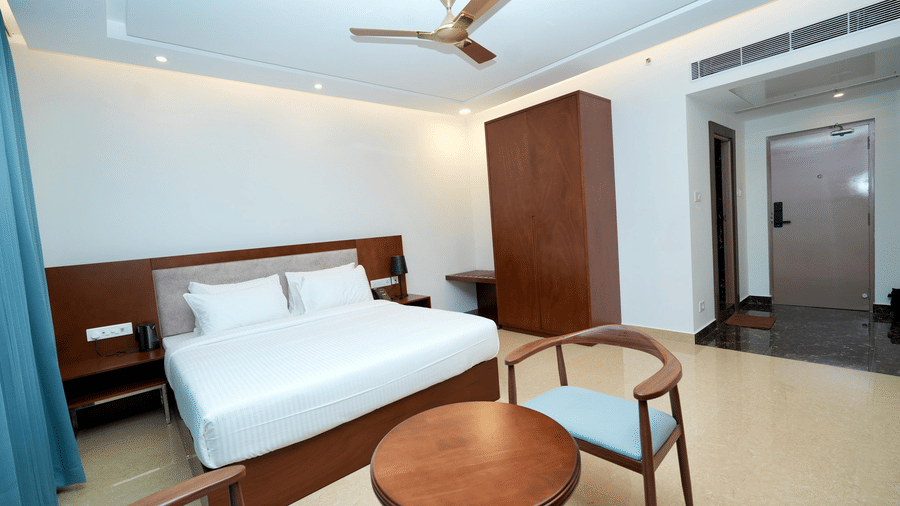 An Executive King Room at Le Royale Palace featuring a king-size bed, seating area, and elegant wooden furnishings