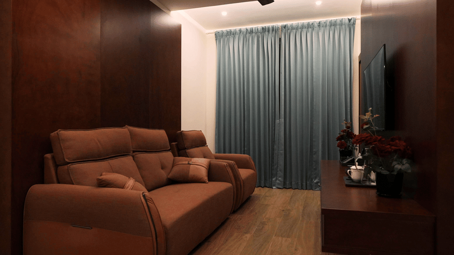 A private living area in the Family Suite at Le Royale Palace with plush sofas, a television, and elegant wooden interiors