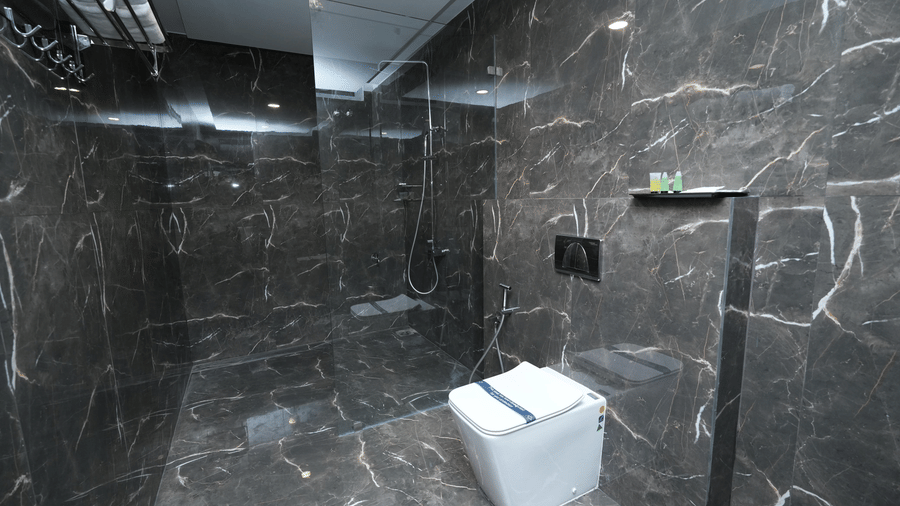 A spacious bathroom in the Majestic Suite at Le Royale Palace showcasing marble interiors and a sleek shower enclosure