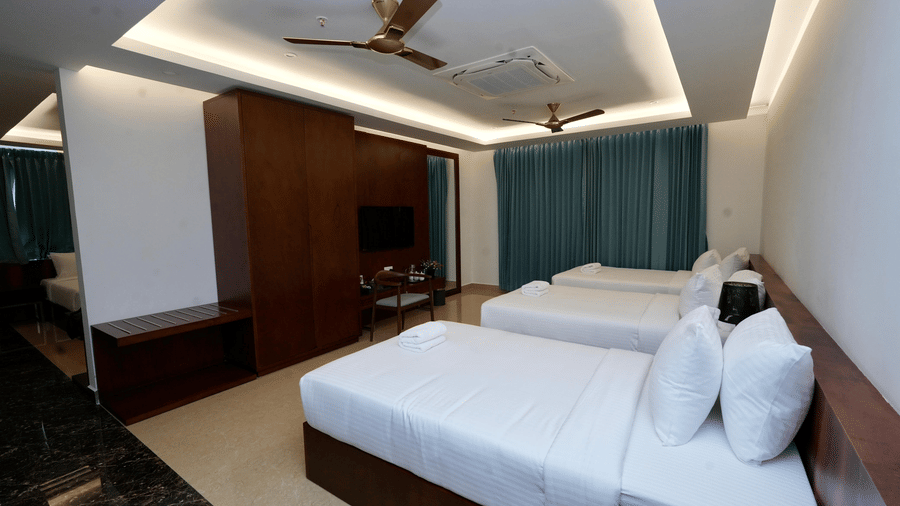 A spacious Standard Family Deluxe Room at Le Royale Palace featuring a double bed, modern ceiling design, and elegant lighting