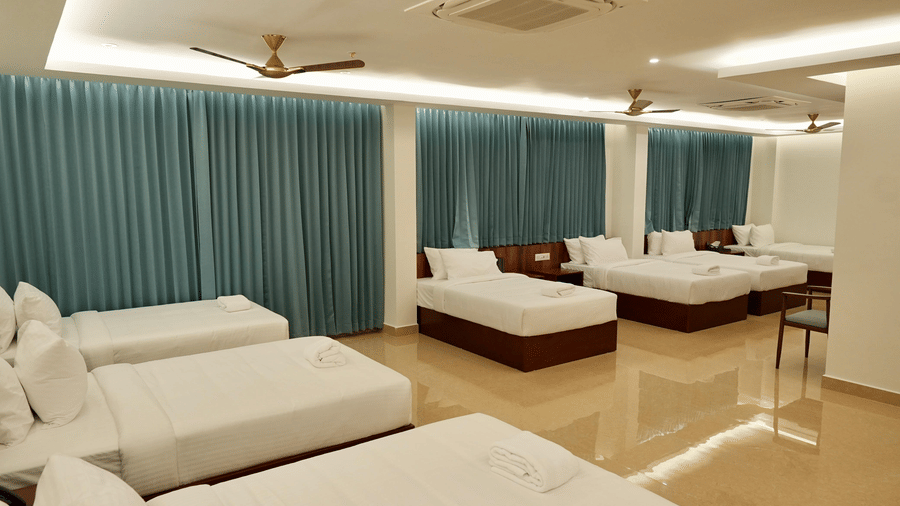 A vanity counter in the Superior Family Room at Le Royale Palace with essential toiletries and fresh flowers placed neatly on a wooden surface