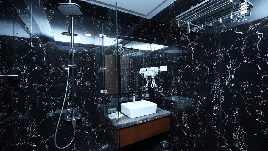 A Superior Family Room bathroom at Le Royale Palace featuring a modern vanity area, mirror, and sleek marble walls