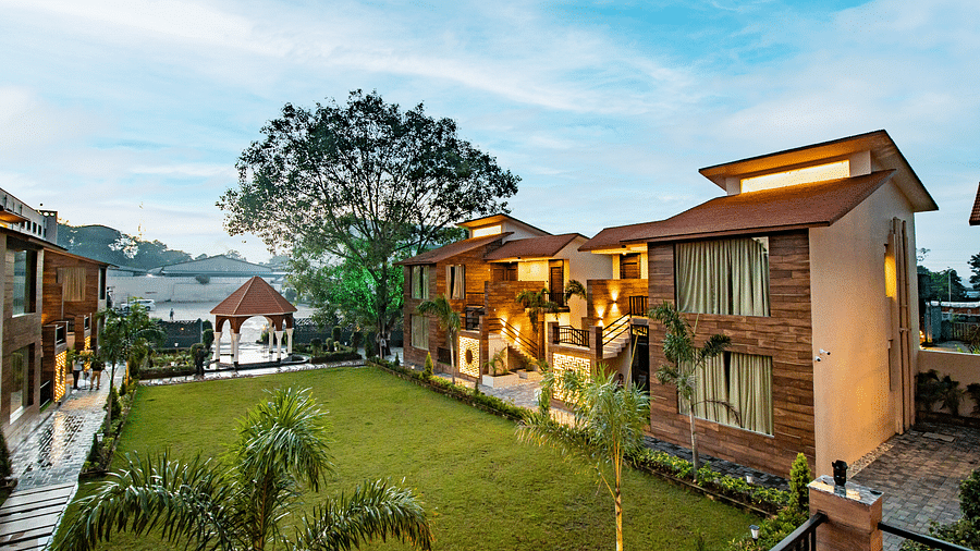 A scenic view of our hotel nestled near the lush lawn beneath the expansive open sky - Wedlock Greens Hotel & Resorts