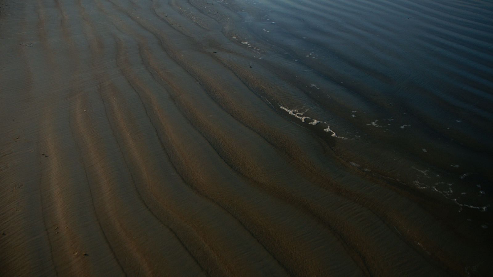 a close up shot of waves made of the sand on Colva beach