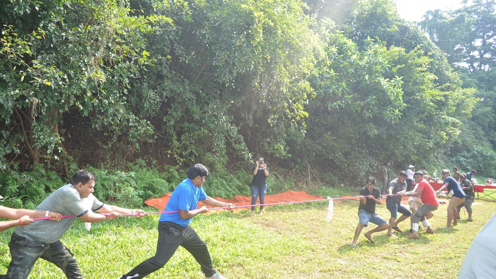 Outdoor activities at Forest Escape include a lively tug-of-war competition amidst the lush greenery.