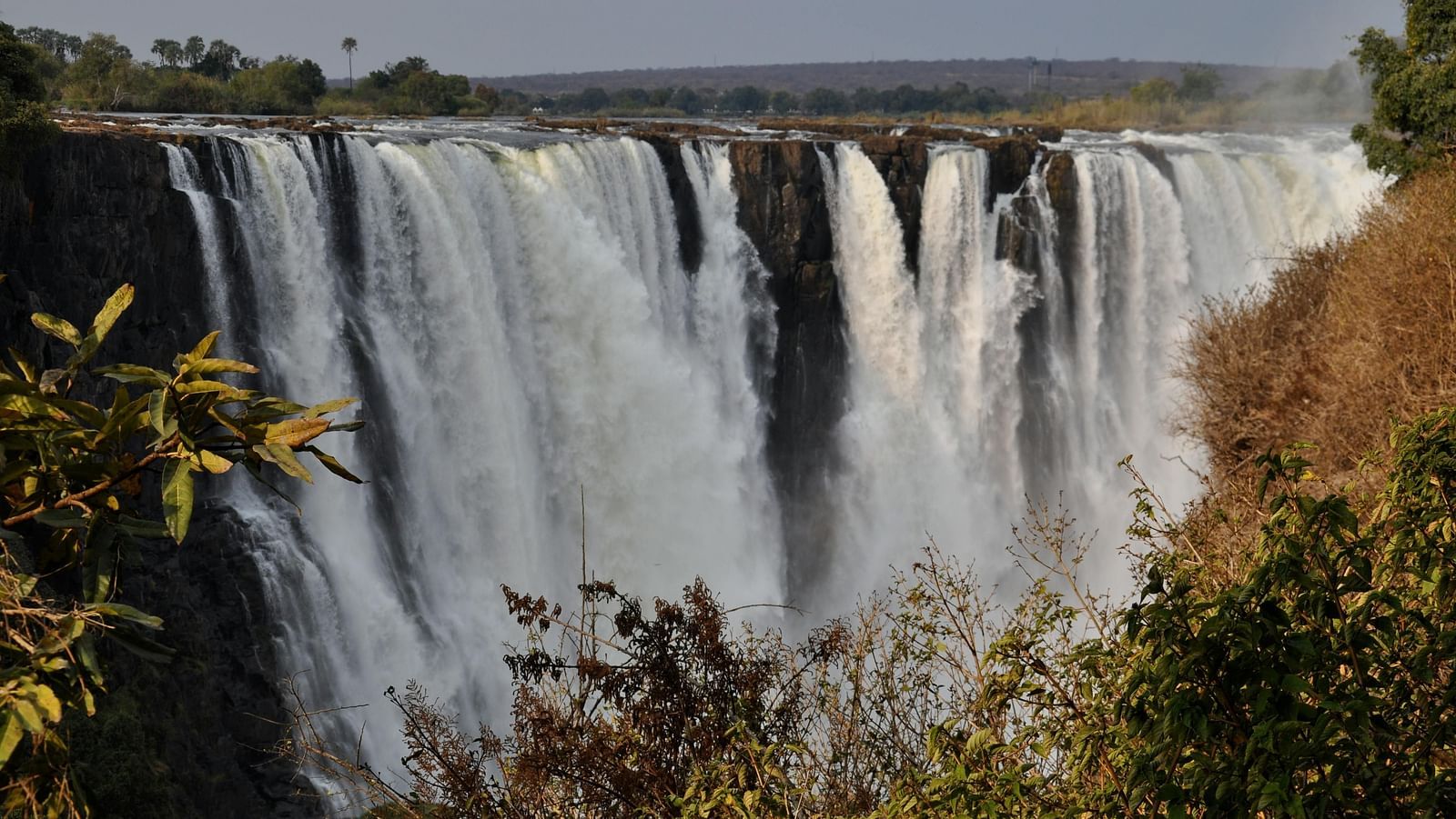 Powerful waterfall plunging over a rocky cliff with mist rising.