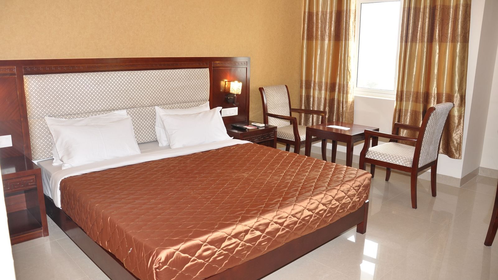 view of a king size bed of a room at Hotel Alps Residency, Krishnagiri