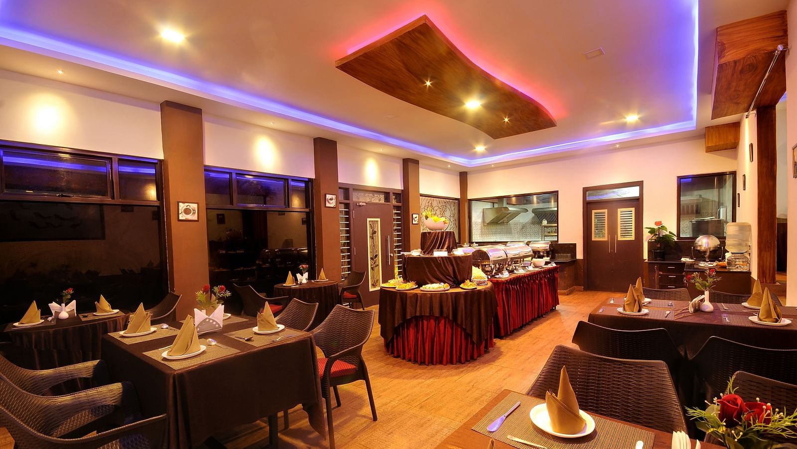Image of a dining space with tables and chairs and lights on the ceiling at Parampara Resort & Spa, Kushalnagar.
