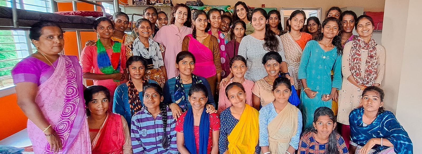 Group of people in colorful clothing posing for a photo, indoor setting - Shreyas Retreat