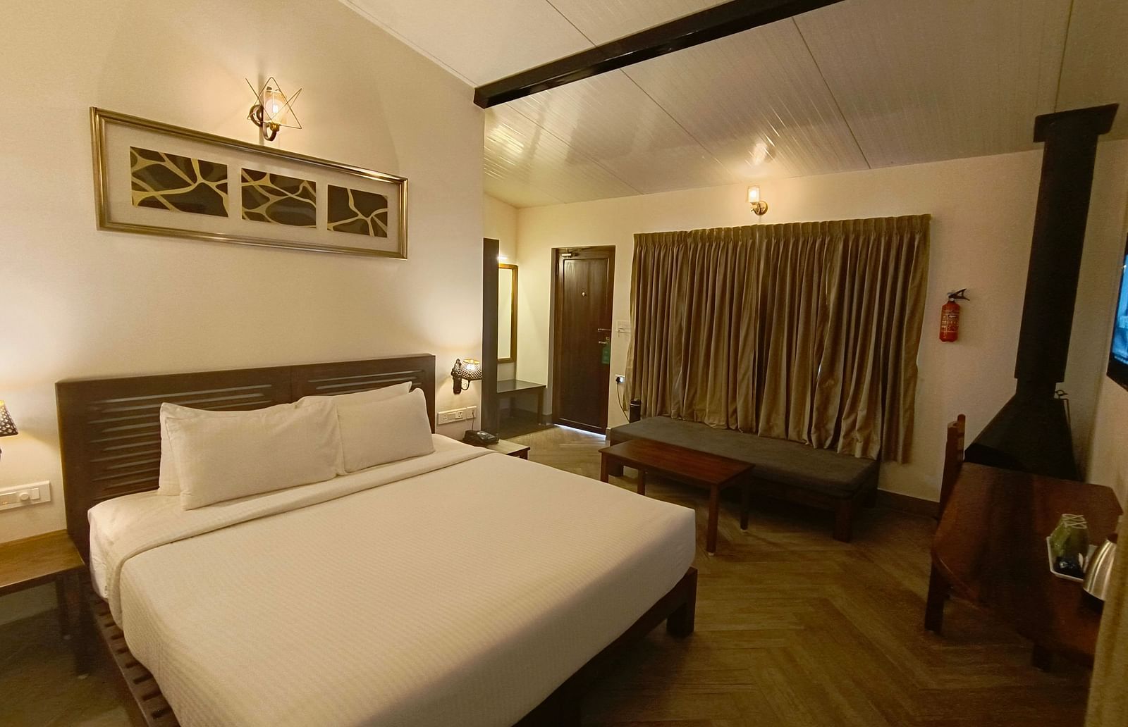 Classic room with a queen-size bed, cozy seating area, and warm lighting.