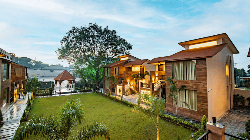 A scenic view of our hotel nestled near the lush lawn beneath the expansive open sky - Wedlock Greens Hotel & Resorts