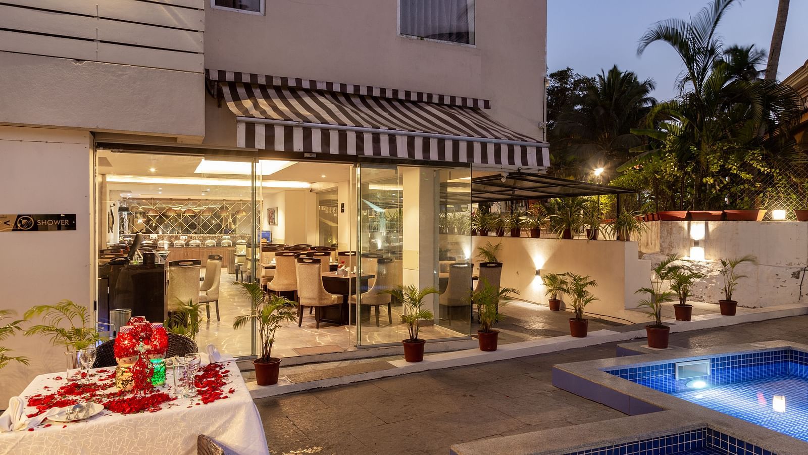Image of poolside dining area with a table decorated with flowers at Calux Grand Baga.