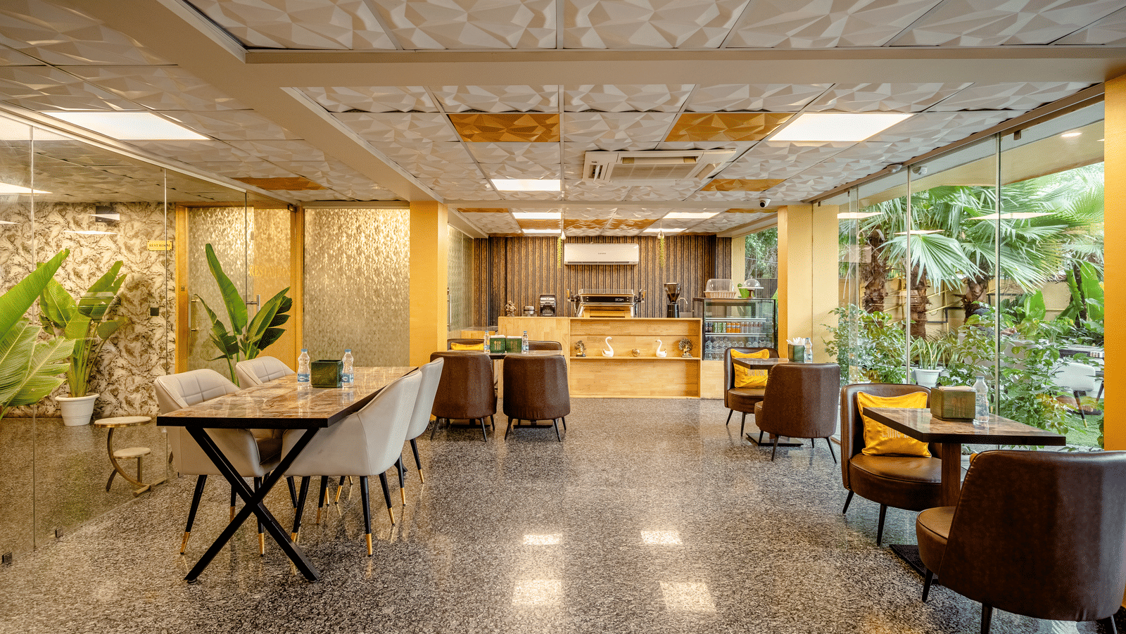 Restaurant at Lime Tree Hotel Near Medanta-The Medicity, Gurgaon featuring dining tables with chairs around them at different parts of the space and there is also a food counter at one side.