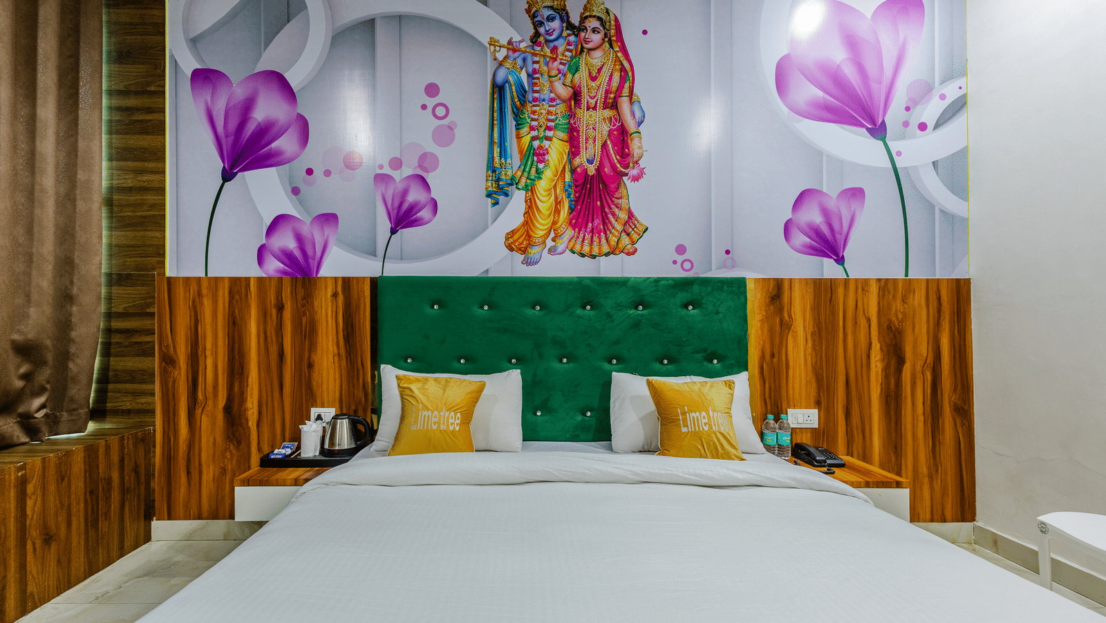A bedroom with a green headboard, wooden panelling, and floral artwork above the bed - Lime Tree Hotels & Banquet, Vrindavan