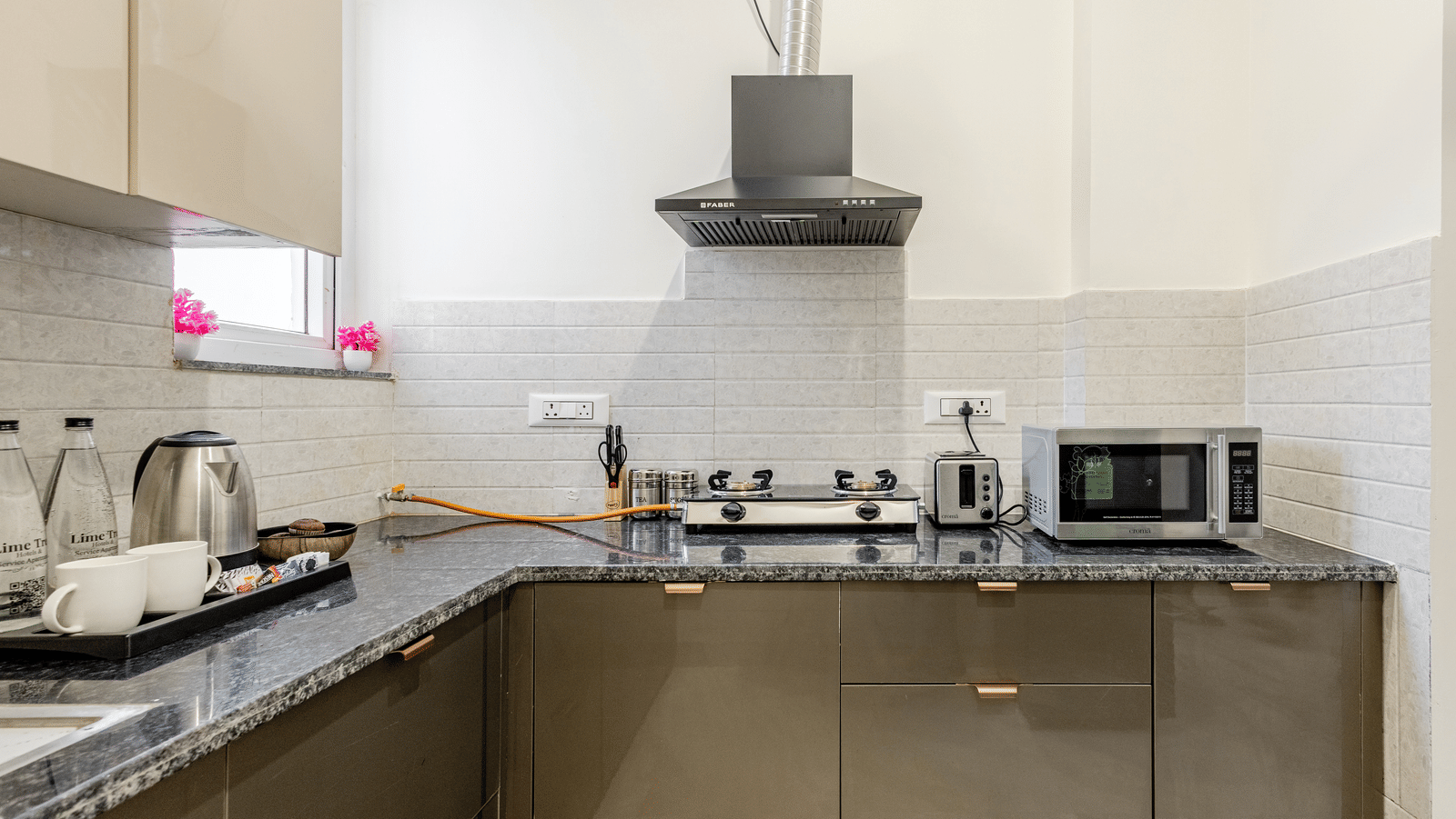 Kitchen of Lime Tree Hotels & Service Apartment Private Limited featuring a countertop, a microwave, and a sink.