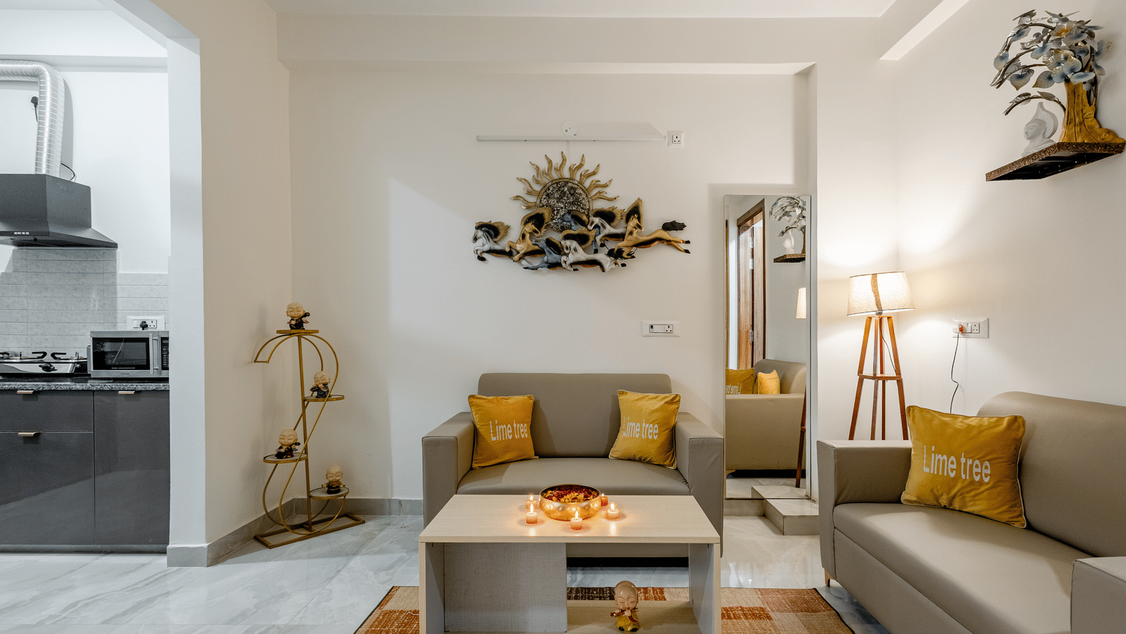 Suite of Lime Tree Hotels & Service Apartment Private Limited featuring a kitchenette, a sofa, and wall mounted decor.