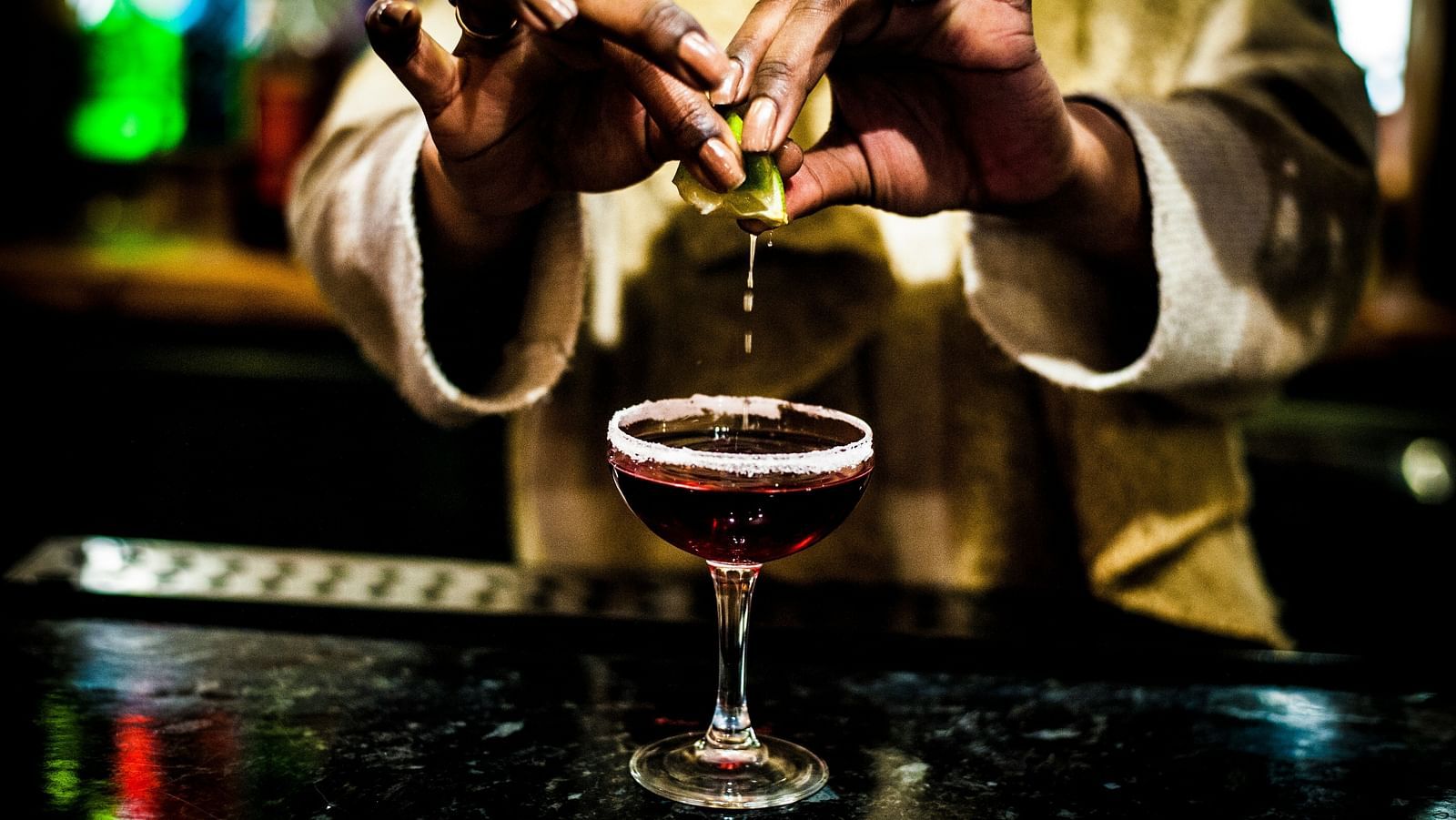 A close-up of a bartender carefully crafting a cocktail