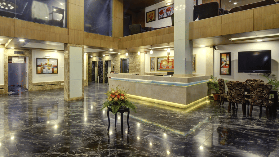 Lobby of Pride Ananya Resort Puri featuring a reception desk and seating chairs and table, and a flat TV screen mounted on the wall.