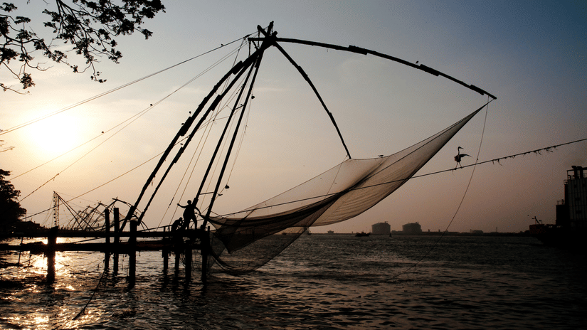 Chinese fishing nets rising from the water as the sun sets over the Fort Kochi waterfront
