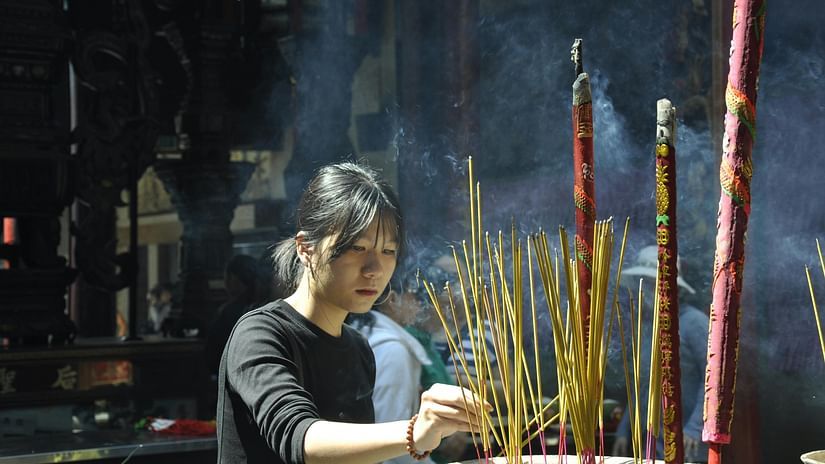 a shot of  a girl offering prayers at temples in prayagraj