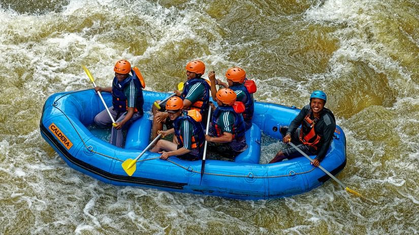 Group of people riding blue raft on ganges river