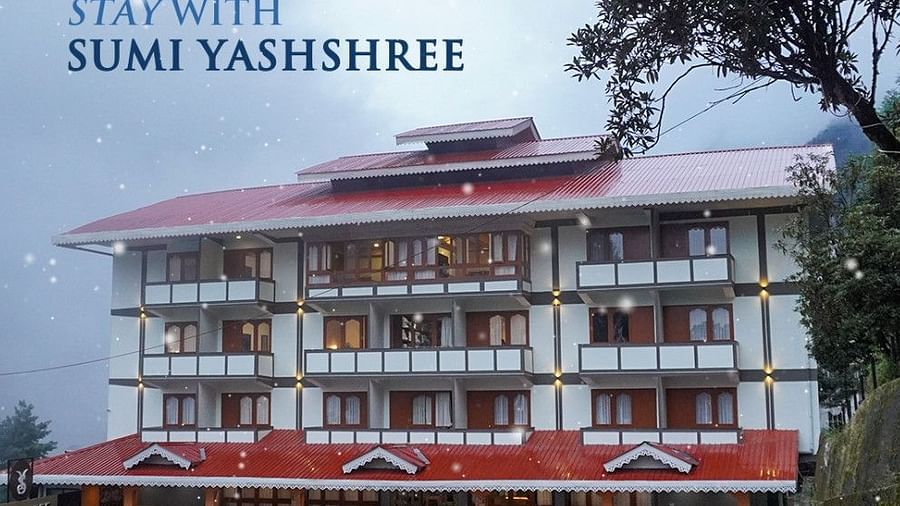 Image of the facade of Yashshree with a background of a clear sky and trees around  | Yashshree Lachung