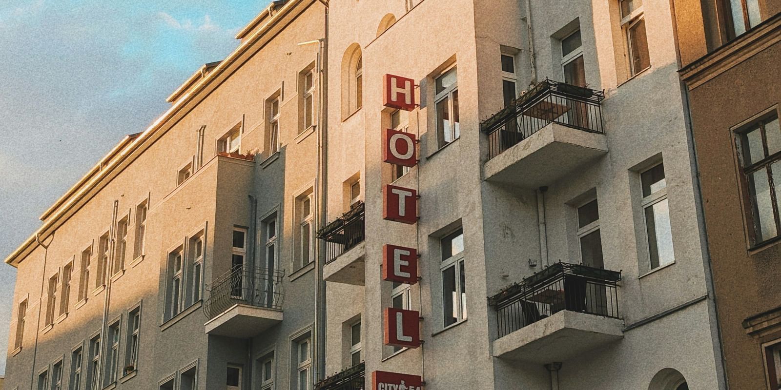  A low-angle view of a row of European-style buildings with balconies under a blue sky