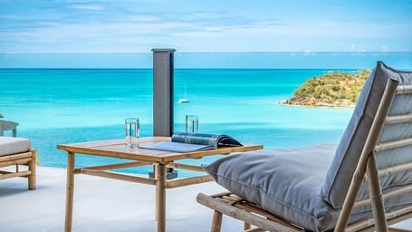 Relaxing beachside loungers at Tamarind Hills Resort and Villas Antigua, overlooking calm Caribbean waves.