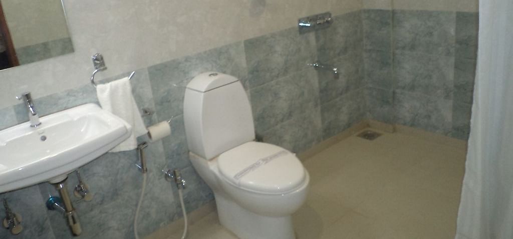 Modern bathroom with toilet, sink, and shower area