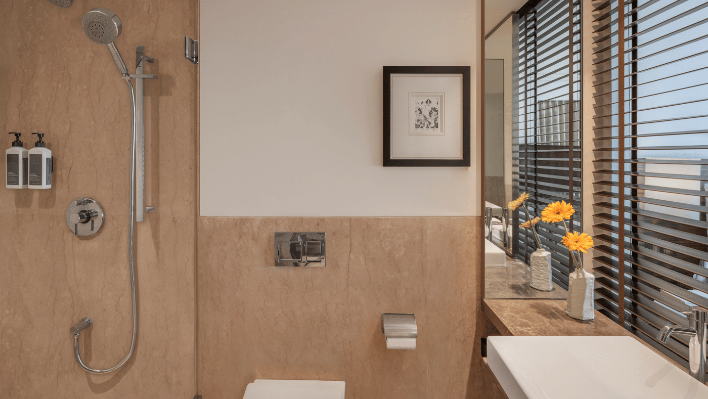 Bathroom with bathtub, sink, and glass divider at The Raintree, St. Mary’s Road.