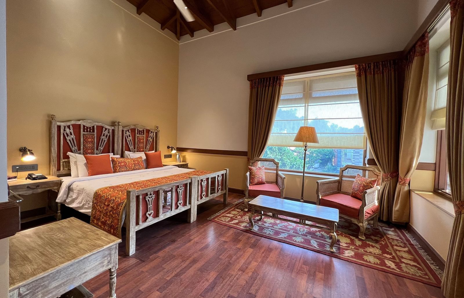  A comfortable Superior Lake Facing Room at Fishermen's Lodge, Bhimtal, featuring a wide open window with stunning views of the lake and surroundings.