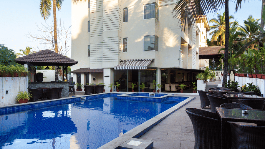 Image of a swimming pool with seating area on the side at Amara Grand Baga, Goa.