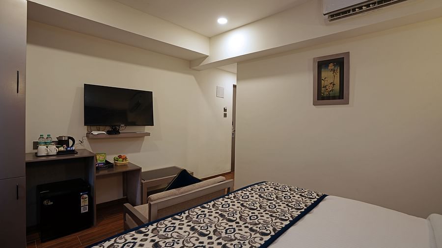 Corner view of the bedroom along with cosy bed there is a TV and electrical kettle on the table at Grand Continent, Anjuna - A Sarovar Portico Affiliate Hotel  